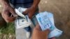 FILE - A man buys dollars from a money changer in Tunis, August 24, 2017. 