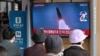 People watch a television screen showing a news broadcast with file footage of a North Korean missile test, at a railway station in Seoul on October 28, 2022, after North Korea fired two short-range ballistic missiles according to South Korea's military. 