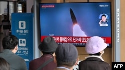 Orang-orang menonton siaran berita yang menayangkan uji coba rudal Korea Utara, di sebuah layar televisi di stasiun kereta api di Seoul, Korsel, 28 Oktober 2022.