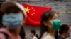 2022年10月1日，北京国庆假期的第一天，人们走在悬挂中国国旗的一条旅游购物街上。