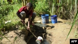 FILE - A boy fetches water from a borehole for domestic use at Mbopo ward, where there is no access to a public water supply, in Dar es Salaam, Tanzania, March 21, 2020. Rains have been short in East Africa since late 2020.