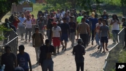 Migrants, mostly from Venezuela, arrive at a camp where Mexican authorities will arrange permits for their continued travel north, in San Pedro Tapanatepec, Oaxaca, Mexico Wednesday, Oct. 5, 2022. (AP Photo/Marco Ugarte)