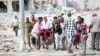 Rescuers and volunteers remove a seriously-injured victim from the scene of a double car-bomb attack in Somalia's capital Mogadishu, Oct. 29, 2022.