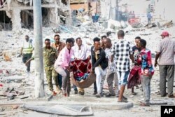 Tim penyelamat memindahkan korban yang terluka parah dari lokasi serangan bom mobil ganda di ibu kota Mogadishu, Somalia Sabtu, 29 Oktober 2022. (AP/Farah Abdi Warsameh)