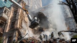 Firefighters work after a drone attack on buildings in Kyiv, Oct. 17, 2022. Waves of explosive-laden suicide drones struck Ukraine's capital as families were preparing to start their week early Monday, the blasts echoing across Kyiv.