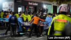 Des secouristes transportent une victime près du lieu du drame à Séoul, Corée du Sud, dimanche 30 octobre 2022. 