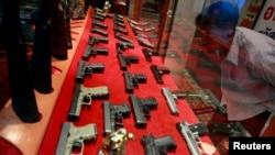 FILE - A man looks at a window display at a gun shop in Bangkok. Thailand has the highest number of guns in civilian hands in Southeast Asia and the highest murder rate by gun in Asia.