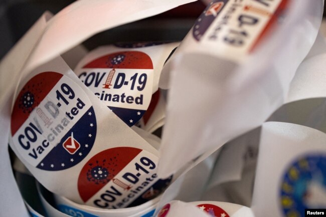 FILE - Patients receive stickers after receiving the coronavirus disease booster vaccine at Skippack Pharmacy in Schwenksville, Pennsylvania, Sept. 8, 2022.