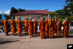 Buddhist monks pray for the victims of a mass killing attack in front on the Young Children's Development Center in Uthai Sawan, north eastern Thailand, Sunday, Oct. 9, 2022.