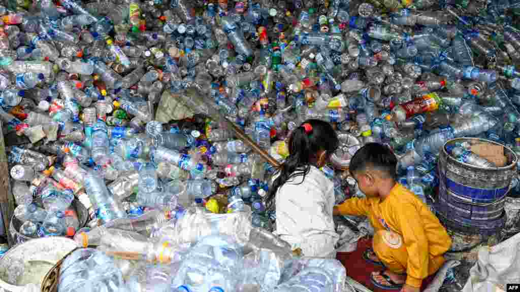 Children play with plastic bottles at a waste collection site in Banda Aceh, Indonesia. 