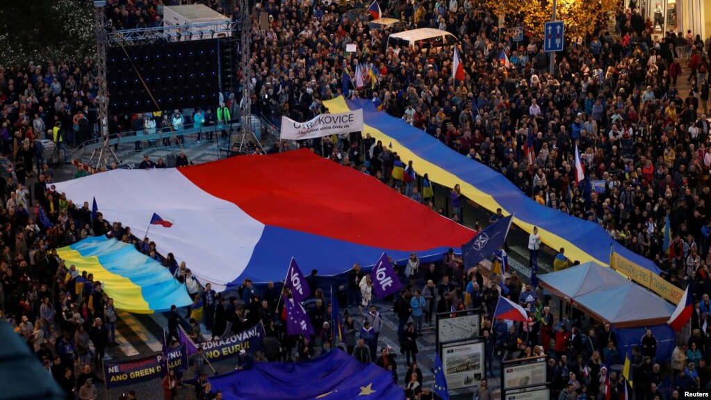 2022 年 10 月 30 日，在捷克共和国布拉格举行的亲政府和反战抗议集会上，示威者举着旗帜。 (photo:VOA)