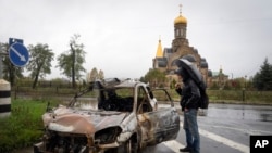 Un transeúnte mira un automóvil dañado por los bombardeos rusos en el centro de Bakhmut, el sitio de la batalla más dura contra las tropas rusas en la región de Donetsk, Ucrania, el 26 de octubre de 2022.