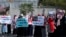 Afghan women hold placards as they take part in a protest in front of the Iranian embassy in Kabul, Sept. 29, 2022. 