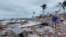 En esta captura de video proporcionado por Bobby Pratt, la gente camina por el área de Times Square en Fort Myers Beach, Florida, después de que el huracán Ian azotara el área, el jueves 29 de septiembre de 2022. (Bobby Pratt vía AP)