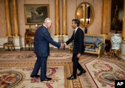 King Charles III welcomes Rishi Sunak during an audience at Buckingham Palace, London, where he invited the newly elected leader of the Conservative Party to become Prime Minister and form a new government, Oct. 25, 2022. (Aaron Chown/Pool photo via AP)