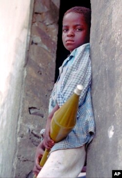 FILE - An 8-year-old Krahn fighter stands at the ready in a front-line position, in Monrovia, Liberia, May 13, 1996. Trial started Oct. 10, 2022, in Paris for a former Liberian rebel accused of crimes against humanity.