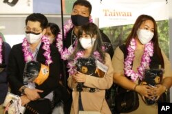 First group of foreign travelers hold souvenirs after arriving at Taoyuan International Airport in Taoyuan, Northern Taiwan, Oct. 13, 2022.