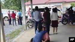 In this image taken from video, a distraught woman is comforted outside the site of an attack at a daycare center, Thursday, Oct. 6, 2022,