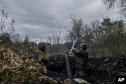 Ukrainian soldiers fire the Russian positions with the mortar in Bakhmut, Donetsk region, Ukraine, Oct. 21, 2022.