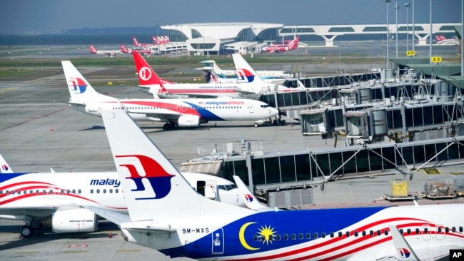FILE - Malaysia Airlines planes taxi at a terminal at Kuala Lumpur International Airport in Sepang, Malaysia, April 1, 2022.