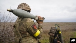 乌克兰国民警卫队的军人在哈尔科夫附近准备向俄军阵地发射迫击炮弹。(2022年10月25日)