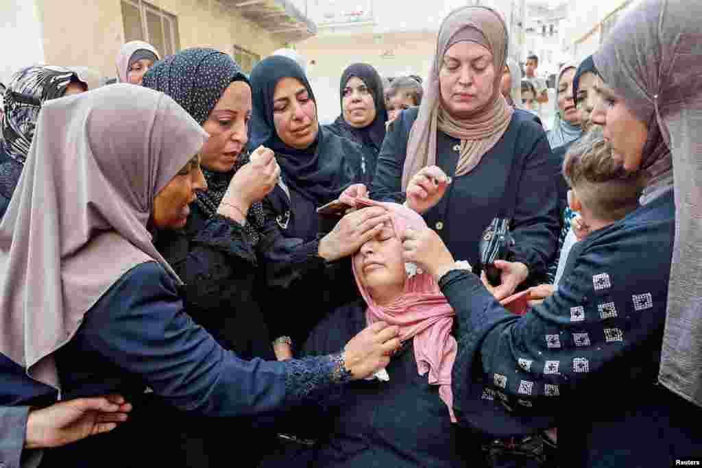 Mourners console the mother of Palestinian Mateen Dbaya, who was killed following an Israeli forces raid in Jenin refugee camp, during his funeral, in the Israeli-occupied West Bank.