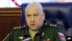 FILE - Colonel General Sergei Surovikin, Commander of the Russian forces in Syria, speaks, with a map of Syria projected on the screen in the back, at a briefing in the Russian Defense Ministry in Moscow, June 9, 2017.