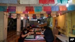 los artesanos hacen "papel en trizas"la elaboración tradicional de adornos cortados con papel tisú que se usa desde hace mucho tiempo en los altares del Día de Muertos, en un taller en Xochimilco, un barrio de la Ciudad de México, el 27 de octubre de 2022.