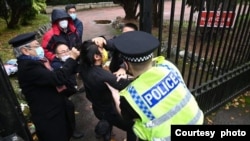 示威者认为参与殴打示威者戴帽子口罩的灰白头发之人（左一）为中国驻曼彻斯特总领事郑曦原。（2022年10月16日）

