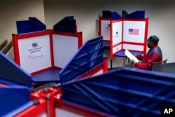 FILE - Cornelius Whiting fills out his ballot at an early voting location in Alexandria, Va., Sept. 26, 2022.