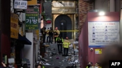 30일 한국 경찰과 소방대원들이 전날 최악의 압사 참사가 발생한 서울 이태원의 좁은 골목길 사고 현장을 조사하고 있다.