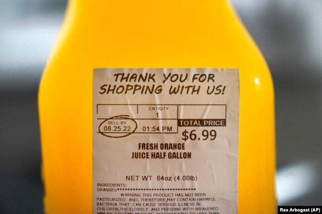 A "SELL BY" date is circled on a half gallon of fresh squeezed orange juice, Sunday, Aug. 21, 2022, in Chicago. (AP Photo/Charles Rex Arbogast)