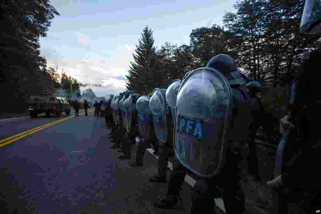 Federal Police line up along a road as they work to evict Mapuche Indigenous people from land they have been occupying for years near Villa Mascardi, Argentina.