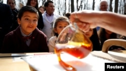 FILE - New Canadian citizen David Alfonso, 8, reacts as maple taffy is prepared for new Canadians following a citizenship ceremony at the Vanier Sugar Shack in Ottawa, Ontario, April 11, 2018. 