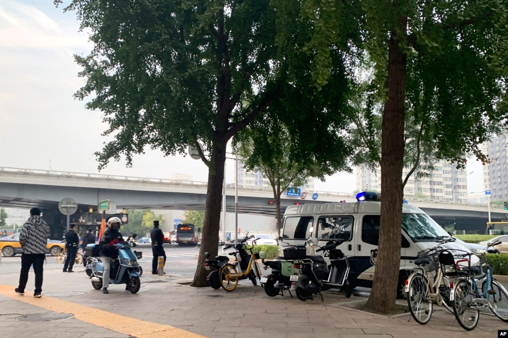 几名警察和一辆警察在北京市海淀区四通桥下执勤。（2022年10月13日）(photo:VOA)