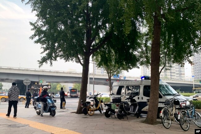 几名警察和一辆警察在北京市海淀区四通桥下执勤。（2022年10月13日）