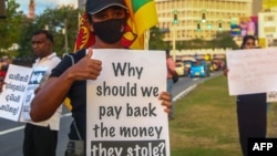 FILE - Protesters hold placards as they take part in an anti-government demonstration in Colombo, Sri Lanka, Sept. 25, 2022.