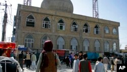 FILE - A Taliban fighter stands guard outside the site of a bomb explosion inside a mosque, in Mazar-e-Sharif province, Afghanistan, April 21, 2022, in this frame grab image from video. The attack was believed to be led by Islamic State in Khorasan Province.