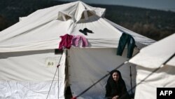 Ilustrasi - Seorang perempuan tua duduk di luar tenda pada 25 Februari 2016 di pusat relokasi untuk migran dan pengungsi di Schisto, dekat Athena.(LOUISA GOULIAMAKI / AFP)