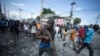 Un manifestante porta un pedazo de madera como si fuera un rifle durante una protesta antigubernamental, el 3 de octubre del 2022, en Puerto Príncipe, Haití. (AP Foto/Odelyn Joseph)