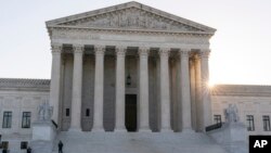 The sun rises behind the U.S. Supreme Court, Oct. 11, 2022, in Washington. 