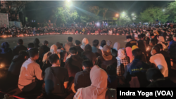 Warga yang berduka pada Senin (3/10) mendatangi salah satu sudut Stadion Kanjuruhan Malang untuk berdoa dan meletakkan karanga bunga. (Foto: VOA/Indra Yoga)