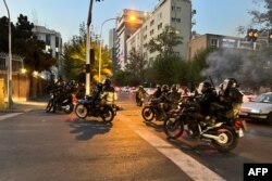 FILE - A picture obtained by AFP outside Iran shows shows Iranian police on motorbikes during a protest in support of Mahsa Amini, a woman who died after being arrested by the Islamic republic's "morality police", in Tehran on Sept. 19, 2022.