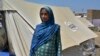 Shakeela Bibi yang sedang hamil berdiri di samping tendanya di kamp bantuan untuk korban banjir, di Fazilpur dekat Multan, Pakistan, pada 23 September 2022. (Foto: AP/Shazia Bhatti)
