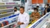 Polisi memeriksa formula sirop obat batuk untuk anak-anak di sebuah toko obat di Banda Aceh, 24 Oktober 2022. (CHAIDEER MAHYUDDIN / AFP)