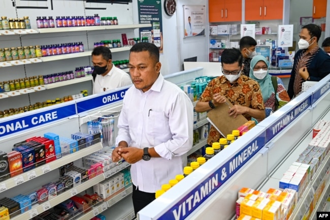 Polisi mengunjungi toko obat di Banda Aceh, untuk memeriksa formula sirup untuk anak-anak, menyusul meningkatnya kematian anak akibat cedera ginjal, 24 Oktober 2022. (CHAIDEER MAHYUDDIN / AFP)