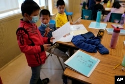 Fourth grade math students look over an exercise at the Alice Fong Yu school in San Francisco, Tuesday, Aug. 30, 2022. The school is the nation's first Chinese immersion public school and provides Cantonese instruction from kindergarten until the 8th grade. (AP Photo/Eric Risberg)