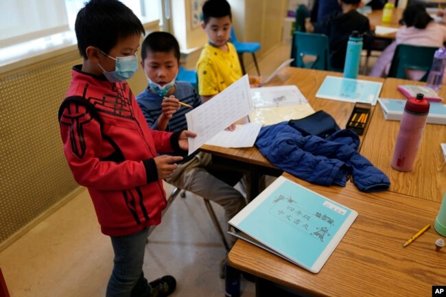 Fourth grade math students look over an exercise at the Alice Fong Yu school in San Francisco, Tuesday, Aug. 30, 2022. The school is the nation's first Chinese immersion public school and provides Cantonese instruction from kindergarten until the 8th grade. (AP Photo/Eric Risberg)