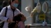 FILE - A child gets swabbed for COVID-19 at a coronavirus testing site in Beijing, Oct. 6, 2022. About 90% of China is fully vaccinated, but only two-thirds of those 80 and older — who are at the highest risk of death — are fully vaccinated against the virus.