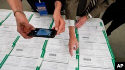 ARCHIVO - Un observador fotografía boletas provisionales del condado de Lehigh mientras continúa el conteo de votos en las elecciones generales, del 6 de noviembre de 2020, en Allentown, Pensilvania, EEUU.
